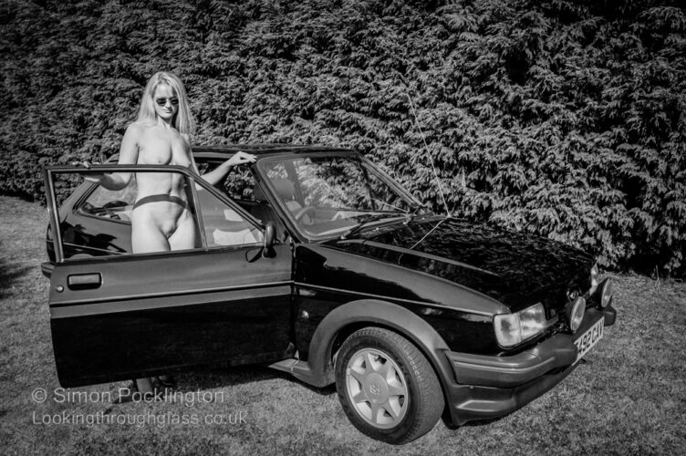 Black and white nude portrait of woman with her car
